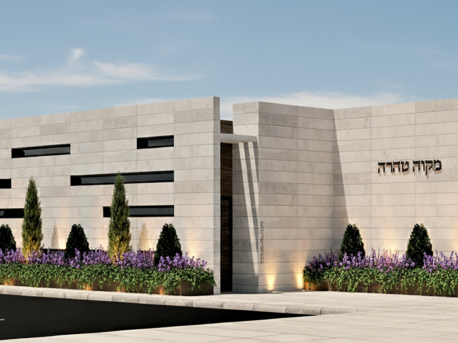 Modern building with landscaped shrubs and trees.